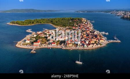 Krapanj, Kroatien - aus der Vogelperspektive auf die Insel Krapanj (Otok Krapanj), die kleinste bewohnte Insel Kroatiens. Yachten, rote Dächer und klarer blauer Himmel Stockfoto