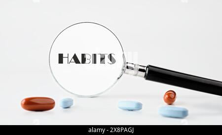 Regelmäßige Tendenz oder Praxis Routinekonzept. GEWOHNHEITEN, geschrieben durch eine Lupe auf hellem Hintergrund. Konzeptfoto Stockfoto