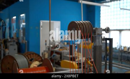 Rotierende Industriemaschine mit Spulen und Drähten. Kreativ. Werkstatt im Industriewerk mit Spinnmaschinen. Stockfoto