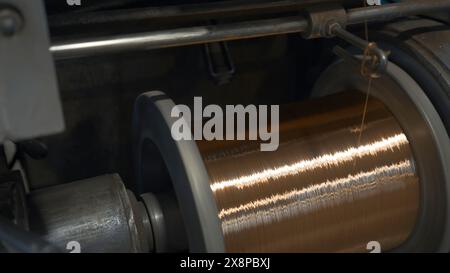 Drehspulen mit Metalldrähten ab Werk. Kreativ. Wicklung von Metallfasern auf Spulen in metallurgischen Anlagen. Verdrehen in Spulen von Stockfoto