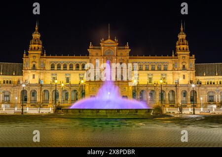 Nachtblick auf die Plaza de España in Sevilla mit dem bunten beleuchteten Brunnen Stockfoto