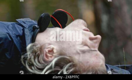 Leiche eines jungen Mannes im Wald. Lager. Der junge Mann starb an den Folgen des Sturzes von einer Klippe im Wald. Steinklippe mit Leiche am Boden des Wassers Stockfoto