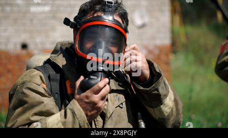 Nahaufnahme Porträt eines starken ernsthaften Feuerwehrmannes in Maske. Clip. Lebensrettungskonzept, heldenhafter Beruf, Brandschutz. Stockfoto