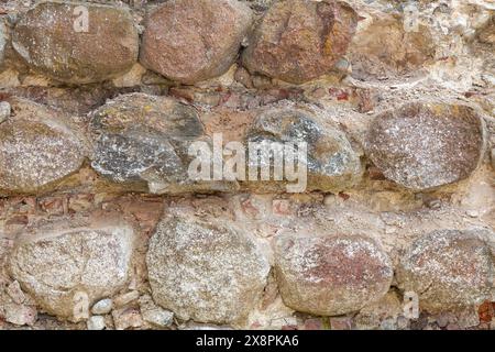 Textur einer alten Mauer aus großen gedrehten Steinen. Stockfoto