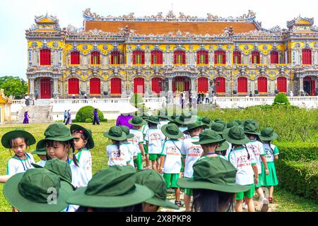 Eine Gruppe vietnamesischer Grundschüler wurde von ihrem Klassenlehrer angewiesen, die verbotene Zitadelle in Hue, Vietnam, zu besuchen Stockfoto