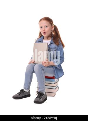 Süße kleine Mädchen sitzen auf Stapel Bücher vor weißem Hintergrund Stockfoto