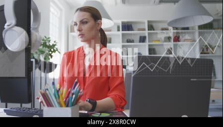 Abbildung von Diagrammen, Ladebalken, Karte über kaukasische Frau, die im Büro auf dem Desktop arbeitet Stockfoto