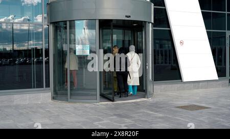 Eine Drehtür in einem modernen Gebäude, Einkaufszentrum. Medien. Drehtür aus Glas, Zugang zum Business Center mit Drehscheibe, Zeitraffer. Stockfoto