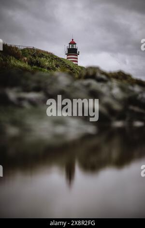 Rot-weiß gestreifter Leuchtturm von Quoddy spiegelt sich im Gezeitenpool, Maine Stockfoto