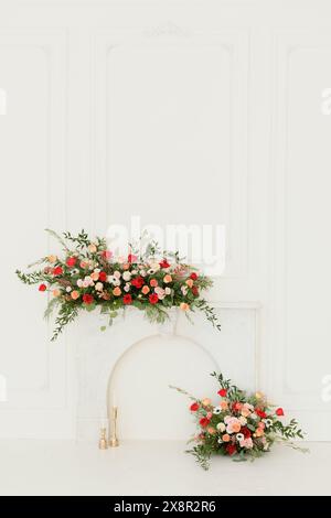 Elegante Blumen auf einem weißen Mantel mit Rosen und Grün Stockfoto