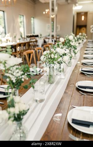 Langer Rezeptionstisch mit elegantem weißem Blumendekor Stockfoto