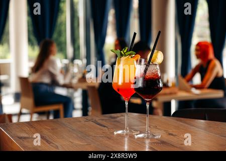 Zwei bunte Cocktails auf einem Restauranttisch mit Leuten Stockfoto