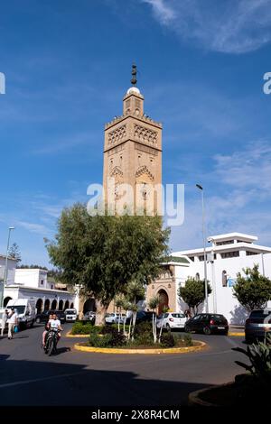 Blick auf den Moscheeturm im Habous-Viertel von Casablanca, Marokko, am 7. Oktober 2023, mit einem Kreisverkehr und Personen auf Motorrädern und Autos in t Stockfoto