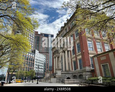 Historisches Gerichtsgebäude mit modernen Gebäuden und Bäumen in Queens, NY Stockfoto