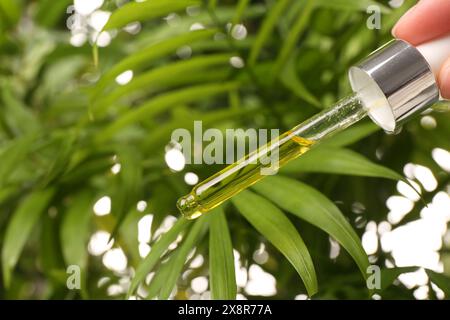 Frau tropft im Freien ätherisches Öl aus der Pipette, Nahaufnahme Stockfoto