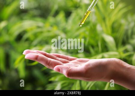 Frau tropft im Freien ätherisches Öl aus der Pipette, Nahaufnahme Stockfoto