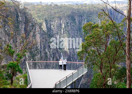 Wollomombi und Chandler Wasserfälle, Paare auf der Aussichtsplattform mit Blick auf die spektakulären Wasserfälle im Oxley Wild Rivers National Park, NSW Stockfoto