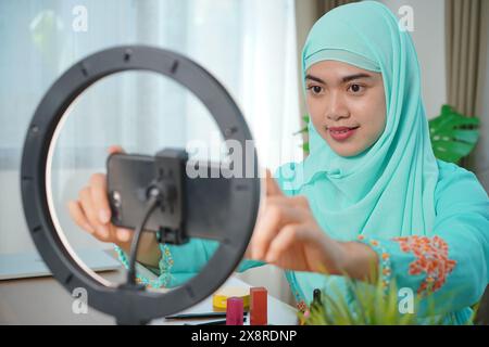 Junge schöne asiatische Frau Vloggerin oder Blogger Aufnahme Make-up Tutorial, um sie in sozialen Medien zu teilen Stockfoto