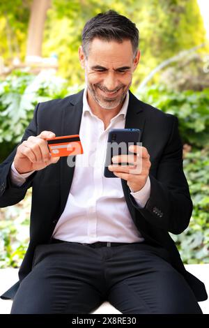Geschäftsmann mit Kreditkartenkauf über eine Online-App mit Smartphone. Stockfoto