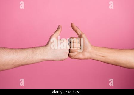 Foto von zwei Menschenhänden, die wie Symbole zusammenstoßen, isolierter Pastellhintergrund Stockfoto