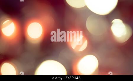 Goldene und rote Bokeh-Lichter schaffen einen weichen, traumhaften Hintergrund, perfekt für eine warme, festliche Atmosphäre Stockfoto