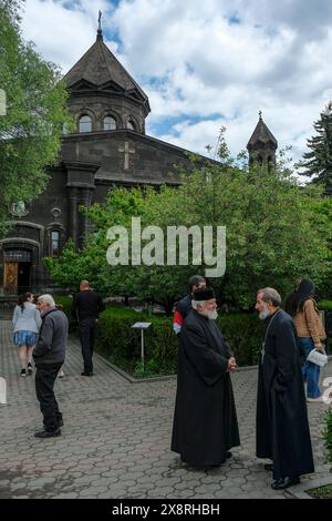 Gyumri, Armenien - 25. Mai 2024: Zwei Priester plaudern vor der Kathedrale der Heiligen Mutter Gottes, auch bekannt als die Muttergottes von sieben Wunden. Stockfoto