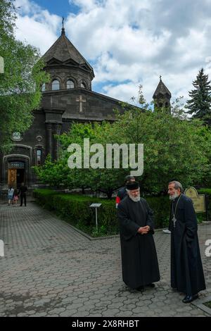 Gyumri, Armenien - 25. Mai 2024: Zwei Priester plaudern vor der Kathedrale der Heiligen Mutter Gottes, auch bekannt als die Muttergottes von sieben Wunden. Stockfoto