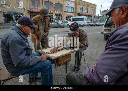 Gyumri, Armenien - 25. Mai 2024: Männer spielen Backgammon auf einer Straße in Gyumri, Armenien. Stockfoto