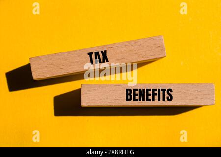 Wörter für Steuervergünstigungen auf Holzblöcken mit gelbem Hintergrund. Symbol für konzeptionelle Steuervorteile. Kopierbereich. Stockfoto