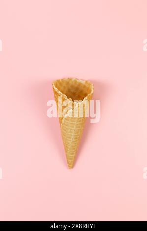 Blick von oben auf Eiswaffelkegel auf rosafarbenem Hintergrund. Sommertapete, flach, Kopierraum. Stockfoto