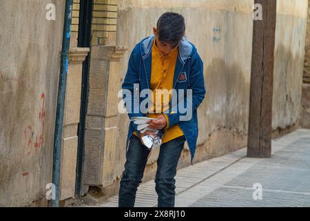 Shiraz, Iran – 31. Dezember 2022: Der Teenager kaufte eine Weißfleckentaube und er denkt auf dem Heimweg eifrig über den Kauf nach Stockfoto