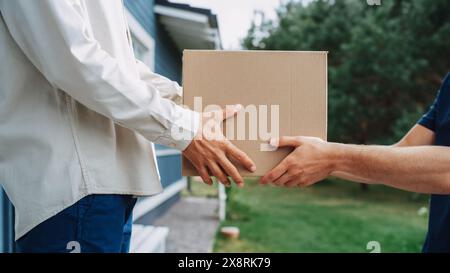 Postbote, der ein Paket an einen Adressaten liefert. Nahaufnahme der Hände eines Postboten des Zustelldienstes, der dem Empfänger eine Pappschachtel überreicht. Mann Erhält Seine Online-Bestellung. Stockfoto