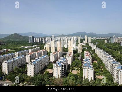 Stadtwohnviertel mit Hochhäusern und Berghintergrund an einem sonnigen Tag/ZouPing Binzhou Shandong China Stockfoto