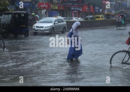 Dhaka. Mai 2024. Am 27. Mai 2024 führt ein Fußgänger durch eine wasserdurchflutete Straße in Dhaka, Bangladesch. Mindestens sieben Menschen starben in Bangladesch an den Verwüstungen des Wirbelsturms Remal, der in der Sonntagnacht Teile des südasiatischen Landes mit starkem Regen und starkem Wind verwüstete. Quelle: Xinhua/Alamy Live News Stockfoto