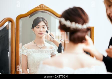 Japanische Braut im Hochzeitskleid, die sich schminkt Stockfoto