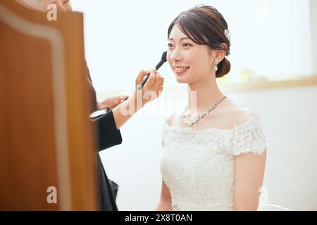 Japanische Braut im Hochzeitskleid, die sich schminkt Stockfoto