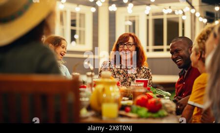 Big Family Garden Barbecue Party Celebration, versammelt an einem Tisch mit Verwandten und Freunden. Junge und Senioren essen, trinken, Essen gehen, scherzen und haben Spaß. Stockfoto