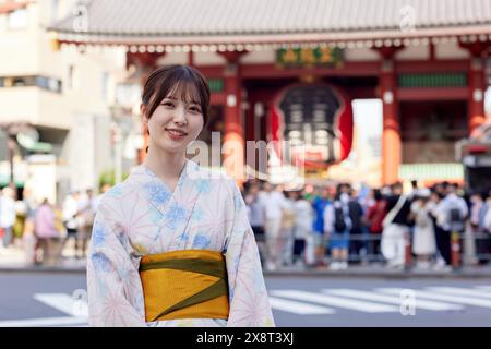 Japanische Frau in einem Yukata, die den traditionellen Tempel in Tokio besucht Stockfoto