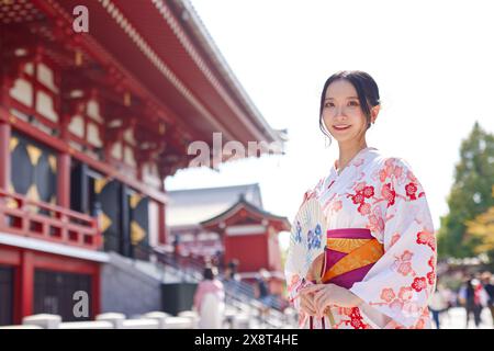 Japanische Frau in einem Yukata, die den traditionellen Tempel in Tokio besucht Stockfoto