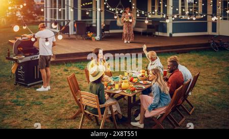 Große Familie und Freunde feiern draußen zu Hause. Verschiedene Gruppen von Kindern, Erwachsenen und alten Menschen versammelten sich an einem Tisch, um lustige Gespräche zu führen. Barbecue vorbereiten und Gemüse essen. Stockfoto