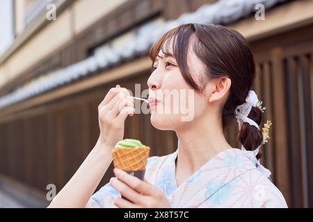 Japanerin in einem Yukata, die das traditionelle Viertel in Tokio besucht Stockfoto