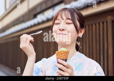 Japanerin in einem Yukata, die das traditionelle Viertel in Tokio besucht Stockfoto