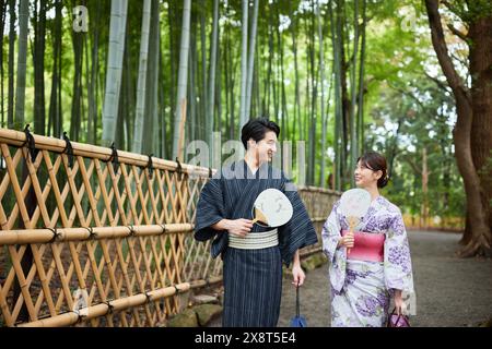 Japanisches Paar, das Yukata trägt, besucht Bambushain Stockfoto