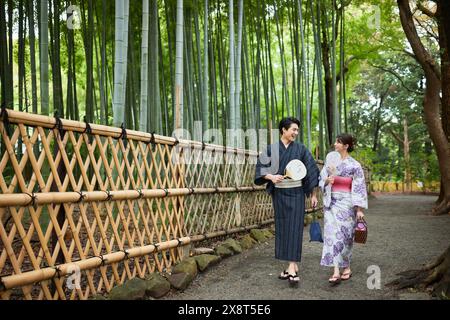 Japanisches Paar, das Yukata trägt, besucht Bambushain Stockfoto