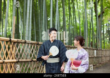 Japanisches Paar, das Yukata trägt, besucht Bambushain Stockfoto