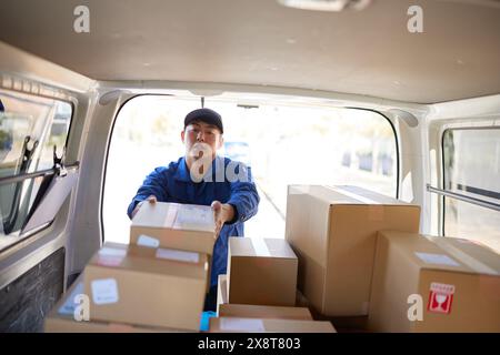 Der japanische Liefermann checkt die Kästchen im Auto Stockfoto