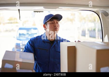 Der japanische Liefermann checkt die Kästchen im Auto Stockfoto