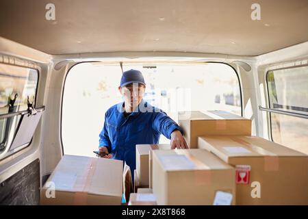 Der japanische Liefermann checkt die Kästchen im Auto Stockfoto