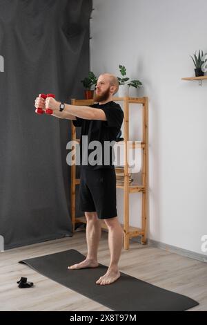 Entschlossener Mann, der mit Kurzhanteln trainiert. Sport- und Erholungskonzept. Stockfoto
