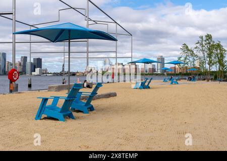 New York, NY - USA - 19. Mai 2024 Nahaufnahme der Liegestühle und Sonnenschirme auf der neuen Gansevoort Peninsula; Manhattans erster öffentlicher Strand mit diesem Stockfoto